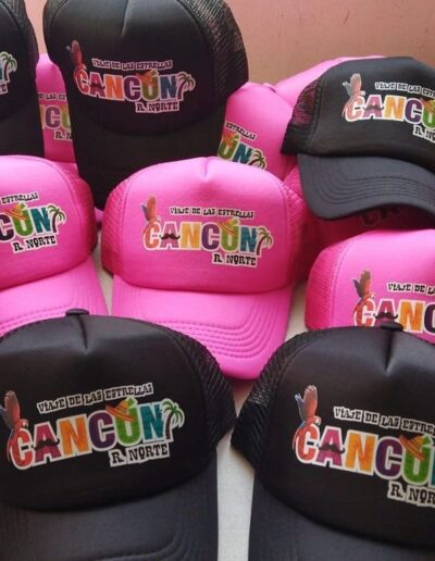 Gorras de camionero rosas y negras con diseño 'Cancún' con palmera, sol y texto 'Viaje de las Estrellas'
