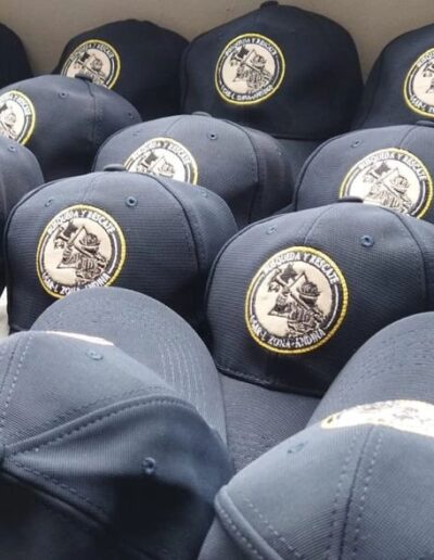 Gorras azul bordadas para bomberos con logo y texto 'BOMBEROS ZONA ANDINA' en hilo dorado.