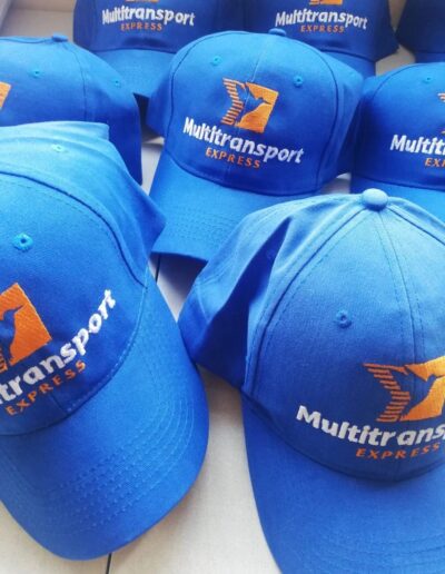 Gorras azules con logo bordado de Multitransport Express, uniformes para empresa de mensajería.